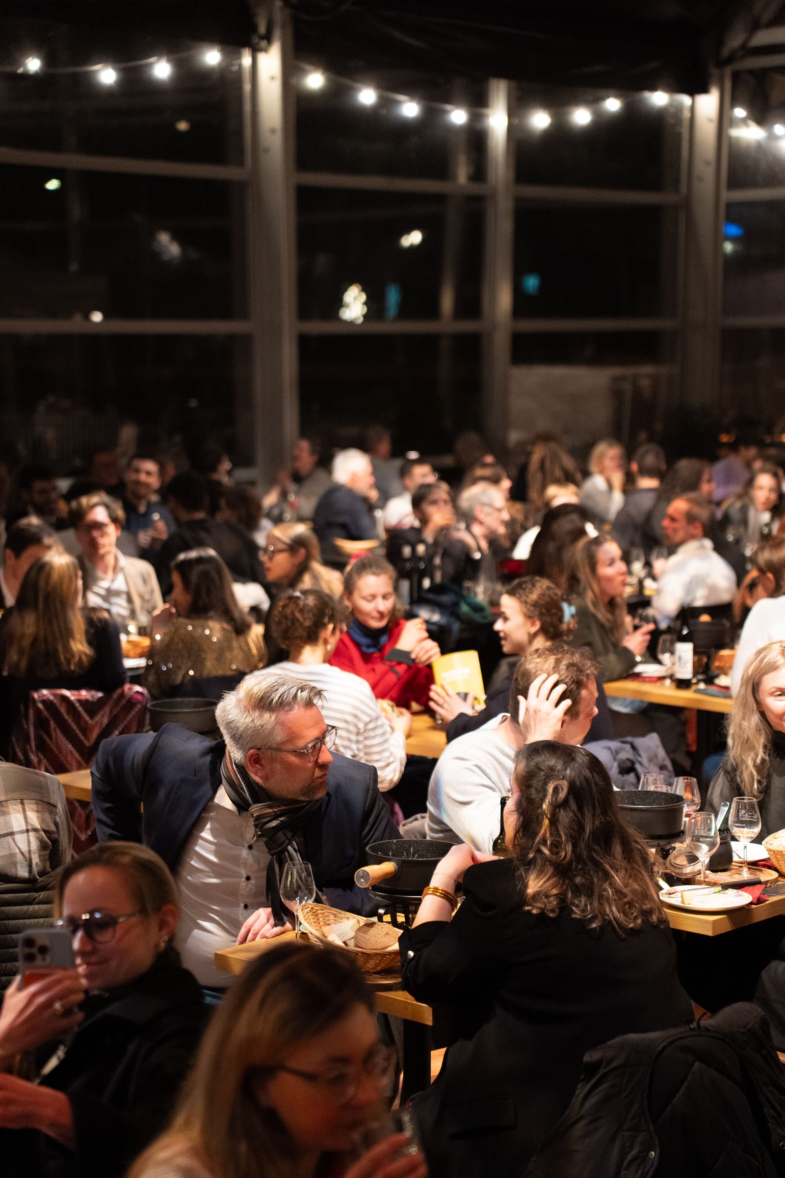 Le public attablé au foyer autour d'une fondue avant le spectacle